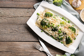 Plate with tasty green lasagna on wooden background