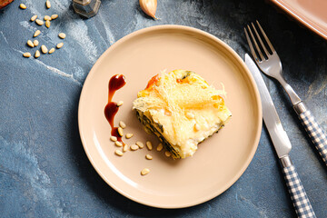 Plate with tasty green lasagna on color background