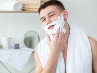 Hygiene morning. Cosmetic product advertising. Male grooming. Joyful smiling young shirtless guy...
