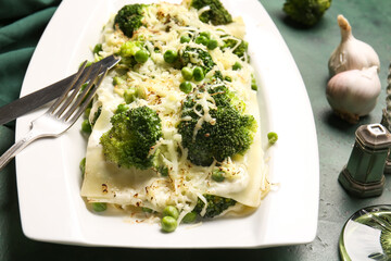 Plate with tasty green lasagna on color background, closeup