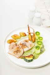 Grilled squid with vegetables. Squid with baby potatoes, zucchini, seasonal vegetables and herbal sauce. Mediterranean Kitchen. Delicious and healthy seafood. Restaurant recipe. Vertical shot