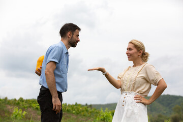 Caucasian man holding papaya behind his back,woman in front of him, relationship, couple, vegetarian