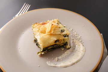 Plate with tasty green lasagna on table, closeup