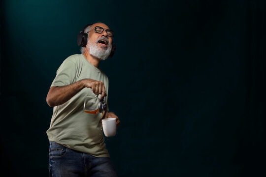 A HAPPY OLD MAN SPILLING COFFEE WHILE DANCING TO MUSIC