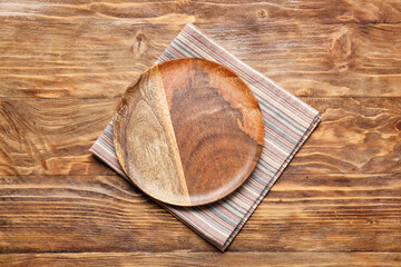 Fototapeta premium Fabric napkin and plate on wooden background