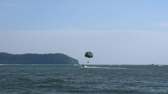 Tourists parasailing on Langkawi exotic island in Malaysia, southeast Asia