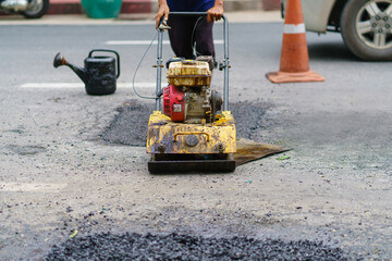 Road repair, Workers and machinery are working paved road with asphalt and gravel, Street construction for land transportation