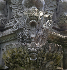 Balinese demon sculpture carved in stone in a temple in Bali, Indonesia