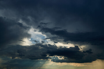beautiful dark dramatic sky with sunlight and clouds as a background