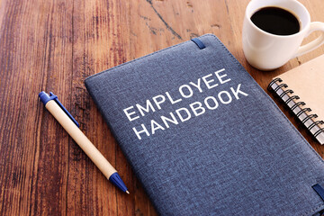Concept image of employee handbook over wooden office table. top view