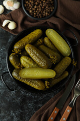 Fresh pickles and spices on black smokey table