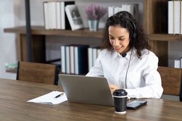 Happy excited successful Beautiful hispanic businesswoman working on laptop computer in modern office. Work from home and social distancing concept.