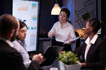 Diverse multi ethnic teamwork brainstorming company ideas analyzing financial graphs presentation....