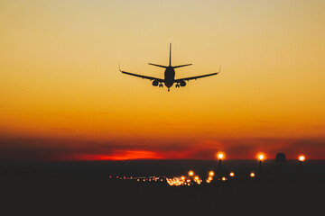 Airplane landing on the runway during sunset and night