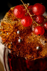 close-up top view of red currant berries on burnt brown caramel crust.