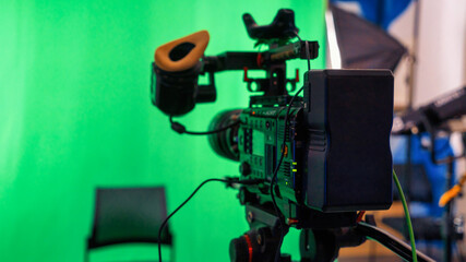 Professional video camera on a stand with green chromakey