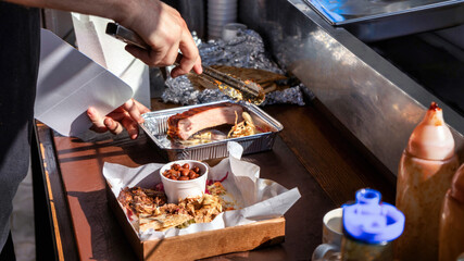 Cook making dishes with meal. Meat and toppings. Food truck
