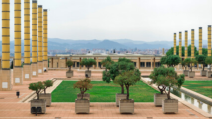 Square with greenery and columns, view of Barcelona