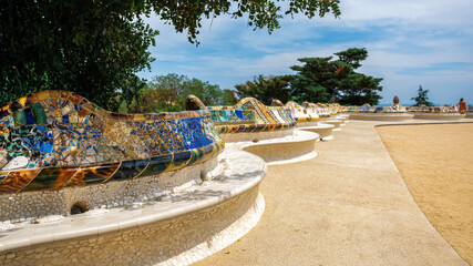 Parc Guell, square with benches made in unusual architectural style in Barcelona