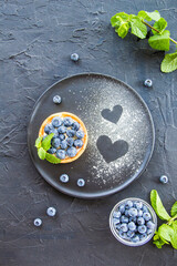 A healthy tasty dessert of cheese blueberry tart. Creative atmospheric decoration