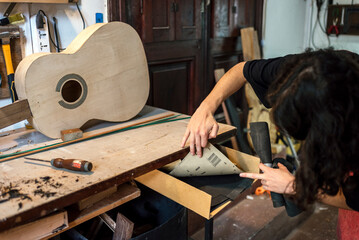 Unrecognized luthier woman in traditional workshop