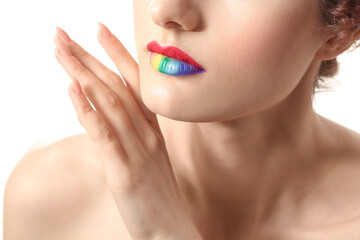 Obraz premium Beautiful young woman with rainbow lips on white background, closeup