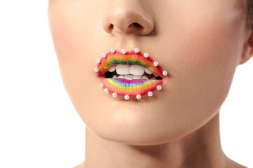 Beautiful young woman with rainbow lips on white background, closeup