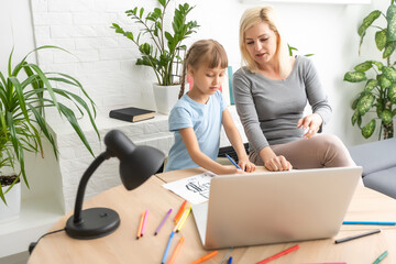 Private lesson. Attentive young woman tutor teacher help little girl pupil with studying math...