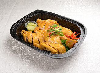 braised freshly hainanese white whole kampong chicken meat with ginger paste sauce in black bento tray box for asian take away halal menu