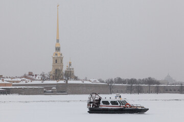 a rescue hovercraft stands on the ice of the Neva River in front of Peter and Paul's fortress