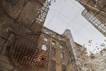 Fototapeta na wymiar Puddle reflection of vintage house courtyard