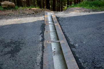 renovation of asphalt road in the mountains. The ditches are filled with stones to slow down the...