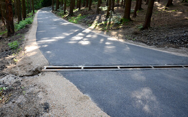 renovation of asphalt road in the mountains. The ditches are filled with stones to slow down the...