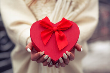 Woman holding a gift box with a heart shape