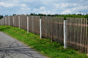 wooden fence made of natural planks. the columns are made of roughly worked gray granite. fencing...