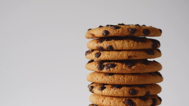 A stack of chocolate chip cookies rotate on a light background. American cookies close-up.place for text