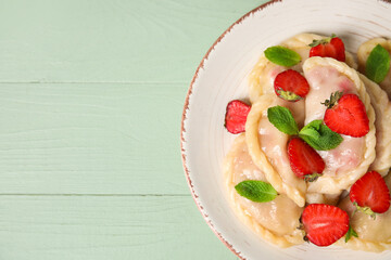 Plate with tasty strawberry dumplings on color wooden background, closeup