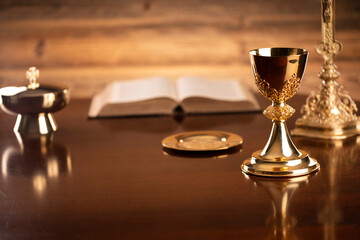 Catholic religion concept. Catholic symbols composition. The Cross, monstrance,  Holy Bible and golden chalice on brown background. 