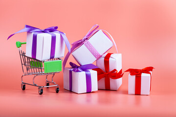 Shopping carts and gifts on a pink background.