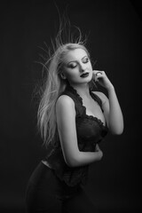 Naklejka premium Seductive woman with bright makeup and hair in wind wears corset