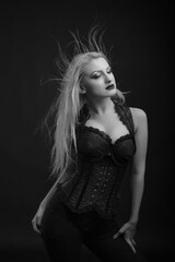 Naklejka premium Sensual woman with bright makeup and hair in wind wears corset