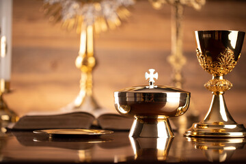 Catholic religion concept. Catholic symbols composition. The Cross, monstrance,  Holy Bible and golden chalice on brown background. 