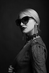 Monochrome studio portrait of a amazing blond woman wears sunglasses and jacket