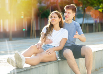 Obraz premium A couple of young people is sitting on the step