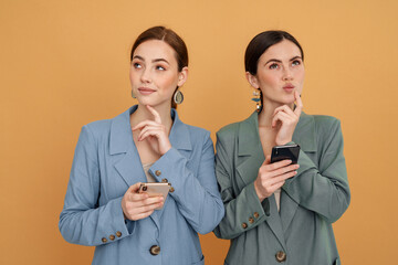 Young two women using mobile phones and looking opposite sides