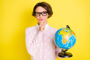 Photo of minded serious young lady hold earth globe hand chin think answer question isolated on...
