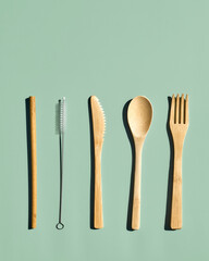 Eco friendly bamboo cutlery set on light green pastel background. Zero waste, plastic-free  lifestyle concept.