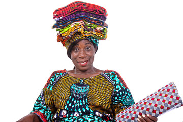 beautiful saleswoman woman holding traditional loincloths on her head smiling.