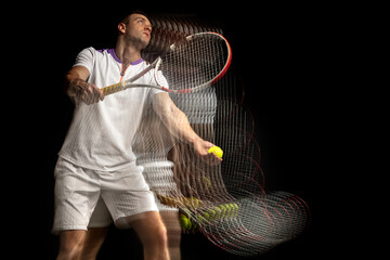 Portrait of young man, male tennis player in motion and action isolated on dark background....