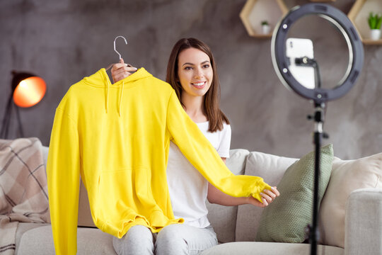 Photo of young attractive girl happy positive smile make video blogging demonstrate jumper hoodie ad home